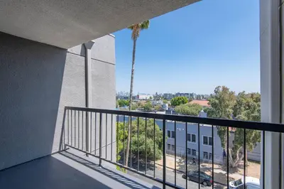 a balcony with a view of a palm tree at Hollywood 1Bed Apt w Rooftop pool & Panoramic View in Los Angeles