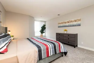a bedroom with a large bed and a dresser at Hollywood 1Bed Apt w Rooftop pool & Panoramic View in Los Angeles