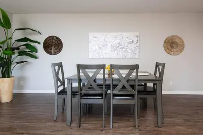 a dining room table with four chairs and a plant at Hollywood 2Bed Apt w Rooftop pool & Panoramic View in Los Angeles