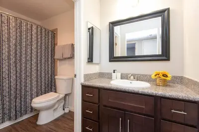 a bathroom with a toilet and a sink and a mirror at Hollywood 2Bed Apt w Rooftop pool & Panoramic View in Los Angeles
