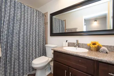 a bathroom with a toilet and a sink and a mirror at Hollywood 2Bed Apt w Rooftop pool & Panoramic View in Los Angeles