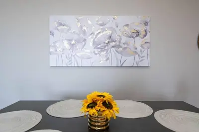 a table with two plates and a vase with yellow flowers at Hollywood 2Bed Apt w Rooftop pool & Panoramic View in Los Angeles
