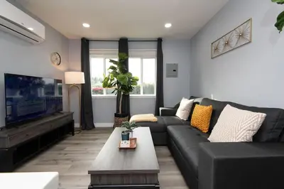a living room with a black couch and a tv at Lovely 3bedroom condo with free parking on premise in Los Angeles