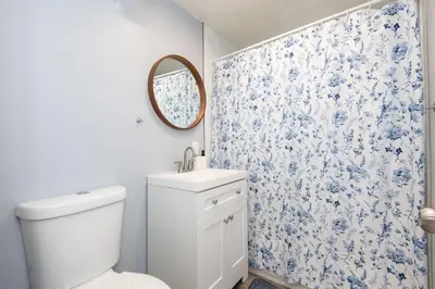 a bathroom with a toilet and a blue and white shower curtain at Lovely 3bedroom condo with free parking on premise in Los Angeles