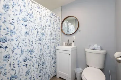 a bathroom with a toilet and a blue and white shower curtain at Lovely 3bedroom condo with free parking on premise in Los Angeles