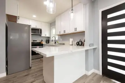 a kitchen with white cabinets and a stainless steel refrigerator at Lovely 3bedroom condo with free parking on premise in Los Angeles