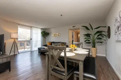 a living room with a dining room table and a couch at Hollywood 2Bed Apt w Rooftop pool & Panoramic View in Los Angeles