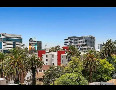 a city skyline with palm trees and buildings at Hollywood 2Bed Apt w Rooftop pool & Panoramic View in Los Angeles