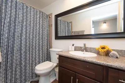 a bathroom with a toilet and a sink and a mirror at Hollywood 2Bed Apt w Rooftop pool & Panoramic View in Los Angeles