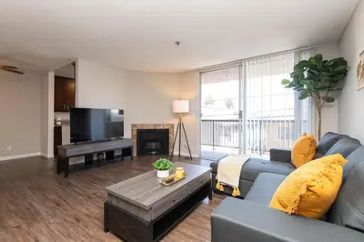 a living room with a blue couch and a tv at Hollywood 2Bed Apt w Rooftop pool & Panoramic View in Los Angeles
