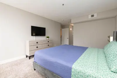 a bedroom with a bed and a tv on a dresser at Hollywood 2Bed Apt w Rooftop pool & Panoramic View in Los Angeles
