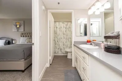 a bedroom with a bed and a bathroom with a sink at Hollywood 2Bed Apt w Rooftop pool & Panoramic View in Los Angeles