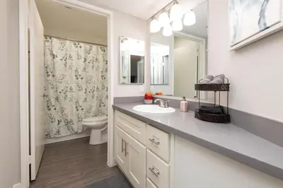 a bathroom with a sink and a toilet and a mirror at Hollywood 2Bed Apt w Rooftop pool & Panoramic View in Los Angeles