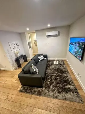 a living room with a black couch and a rug at Luxury 1BR Malibu Bungalow on PCH + steps from Beach! in Malibu
