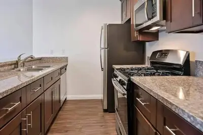 a kitchen with a stove and a stainless steel refrigerator at Hollywood 2Bed Apt w Rooftop pool & Panoramic View in Los Angeles