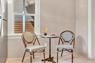 two chairs and a table in a room with a window at East Village Apartments in Long Beach