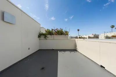 a balcony of a white building with plants on it at Carnelian Calm-Pool BBQ Rooftop Walk to the Beach in Los Angeles