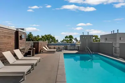 a rooftop patio with a swimming pool and lounge chairs at Carnelian Calm-Pool BBQ Rooftop Walk to the Beach in Los Angeles