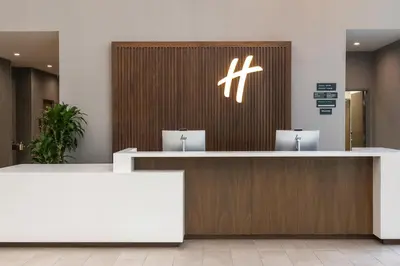 a reception counter in a hospital with a cross on the wall at Holiday Inn & Suites Monterey Park – Los Angeles by IHG in Monterey Park