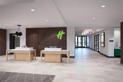 a lobby with two tables in a building at Holiday Inn & Suites Monterey Park – Los Angeles by IHG in Monterey Park