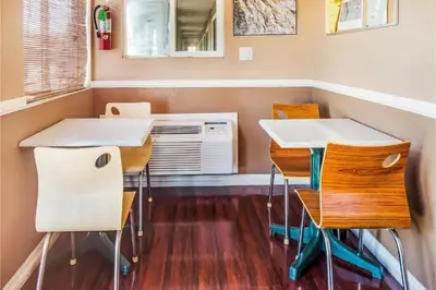 a room with two tables and chairs and a microwave at Hotel Europa Ridgecrest in Ridgecrest