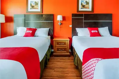 two beds in a hotel room with red walls at Hotel Europa Ridgecrest in Ridgecrest