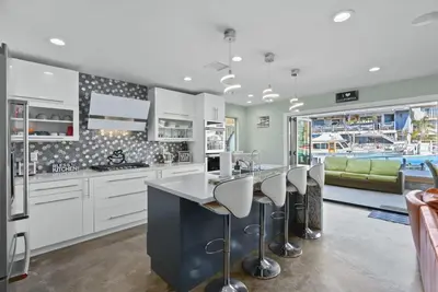 a kitchen with white cabinets and a bar with stools at Voted Airbnb Most Loved Home 2024 Duffy Boat in Huntington Beach