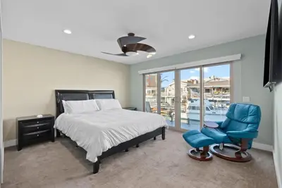a bedroom with a bed and a blue chair at Voted Airbnb Most Loved Home 2024 Duffy Boat in Huntington Beach