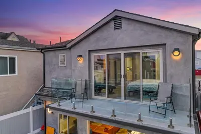 a house with a deck with chairs and a bed at Voted Airbnb Most Loved Home 2024 Duffy Boat in Huntington Beach