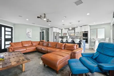 a living room with a brown leather couch and chairs at Voted Airbnb Most Loved Home 2024 Duffy Boat in Huntington Beach