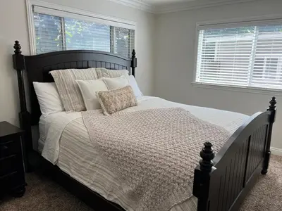 a bedroom with a large bed with white sheets and pillows at Destination #04 in Anaheim