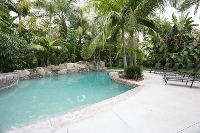 a large swimming pool with chairs and palm trees at Destination #03 in Fullerton