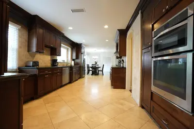 a kitchen with wooden cabinets and a tile floor at Destination #03 in Fullerton