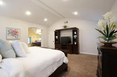 a bedroom with a white bed and a television at Destination #08 in Anaheim