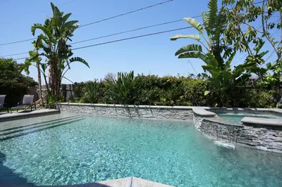 a swimming pool with turquoise water and palm trees at Nostalgic PoolJacuzzi Home: GameRm1.8 Mi 2Disney in Anaheim