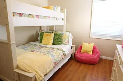 a bedroom with a bunk bed and a red chair at Destination #13 in Anaheim