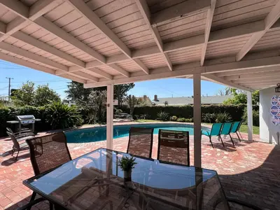 a patio with a glass table and chairs under a pergola at Destination #13 in Anaheim