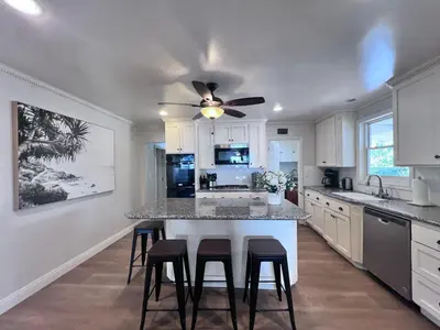 a kitchen with a ceiling fan and a kitchen island with stools at Destination #13 in Anaheim