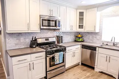 a kitchen with white cabinets and stainless steel appliances at Destination #37 in Fullerton