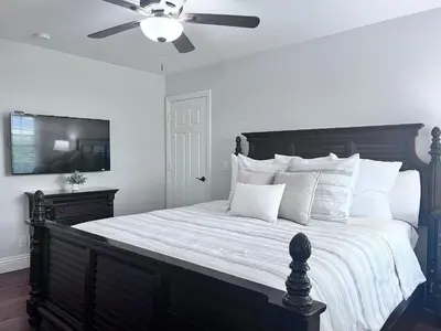 a bedroom with a large bed with a ceiling fan at Destination #09 in Anaheim