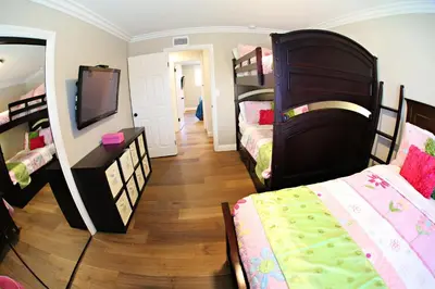 a room with two beds and a tv and a mirror at Destination #21 in Anaheim