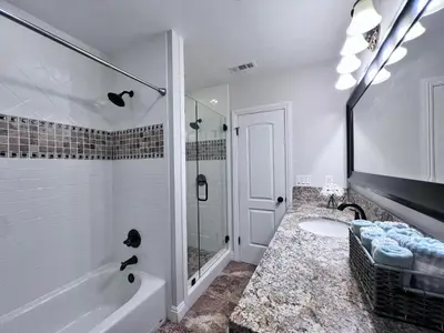 a bathroom with a tub shower and a sink at Destination #28 in Anaheim