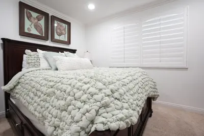 a bedroom with a bed with a white blanket and a window at Destination #16 in Anaheim