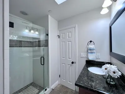 a bathroom with a glass shower and a sink at Destination #30 in Anaheim
