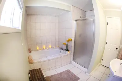 a bathroom with a tub and a shower with candles at Destination #18 in Anaheim