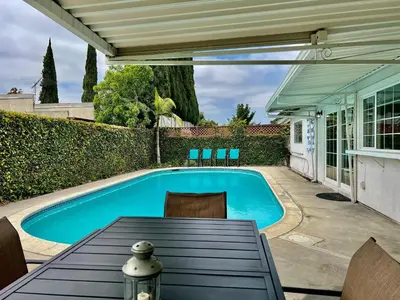 a swimming pool in a backyard with a table and chairs at Destination #18 in Anaheim