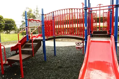 a playground with a red slide in a park at Destination #20 in Anaheim