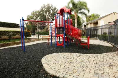 a playground with a red slide in a park at Destination #20 in Anaheim