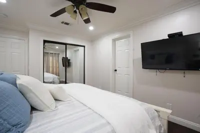 a bedroom with a bed with a flat screen tv on the wall at Destination #22 in Anaheim