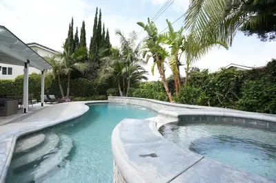 a swimming pool in a yard with palm trees at Destination #39 in Orange